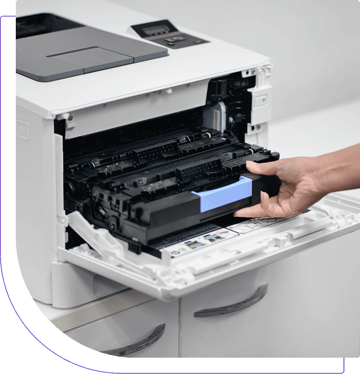 A person replacing a toner cartridge in a printer.