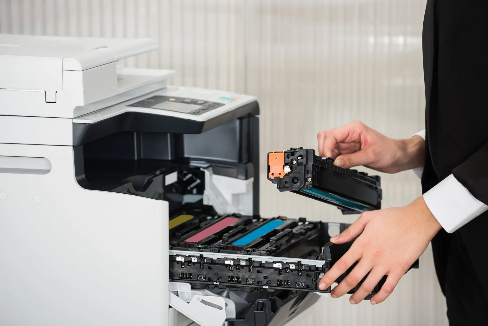 A person replacing a toner cartridge in a printer.