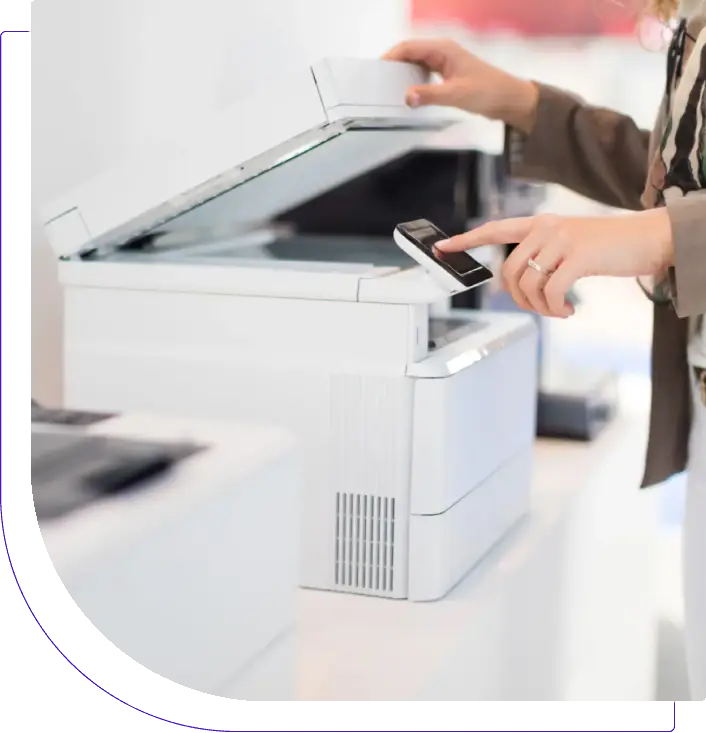Person using a copier machine to scan or copy documents.